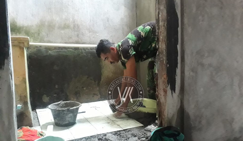 Anggota+TNI+tengah+memperbaiki+jamban+warga